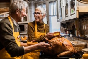 senior-couple-preparing-turkey-for-thanksgiving